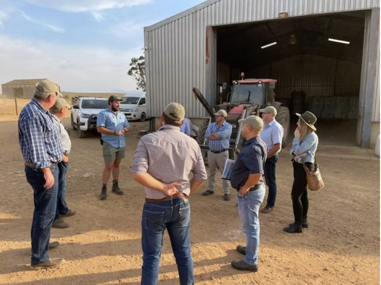Farm briefing with growers outside an equipment shed