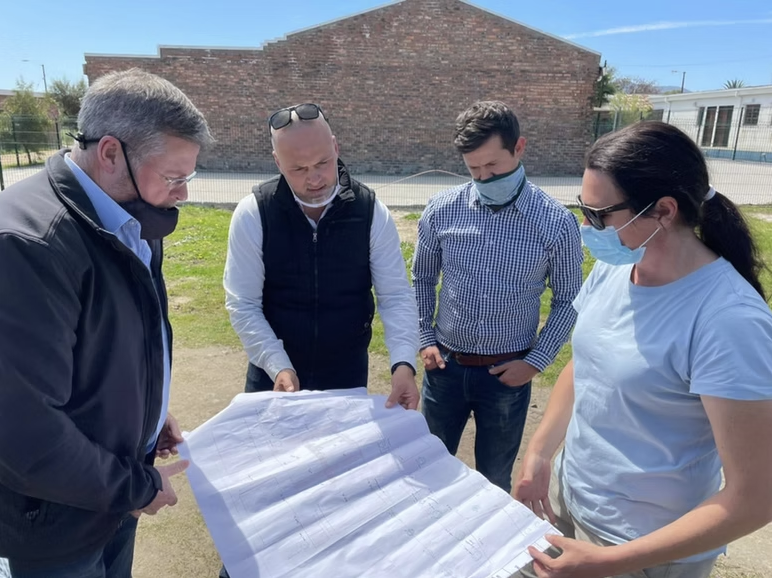 Team reviewing site plans on location during a facility expansion